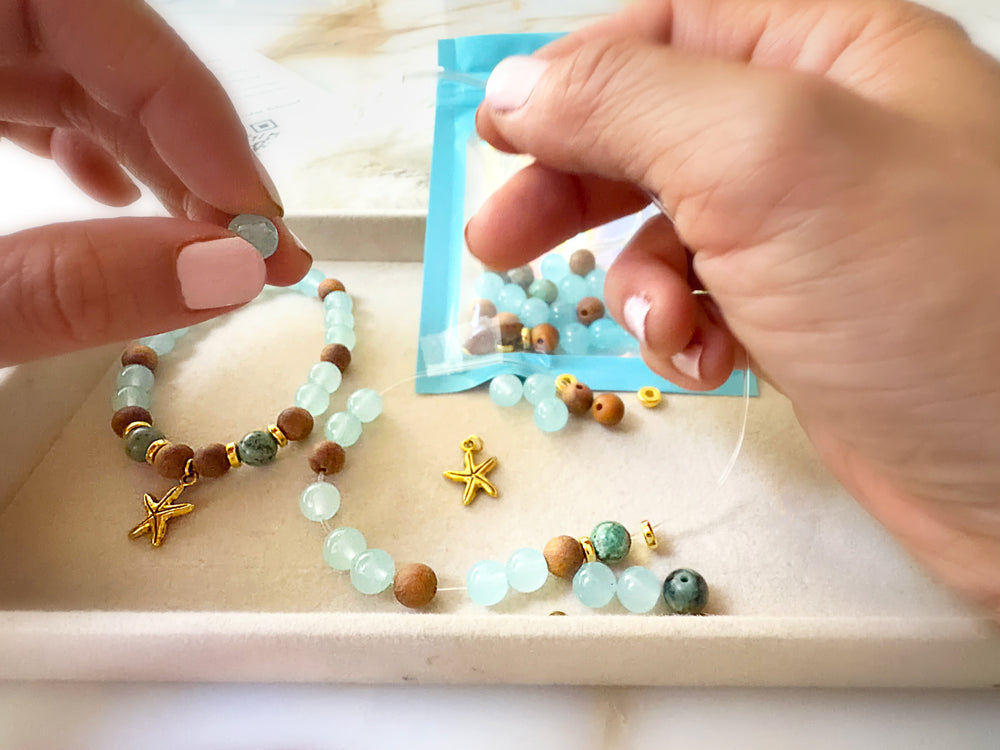 Hands making a gemstone bracelet
